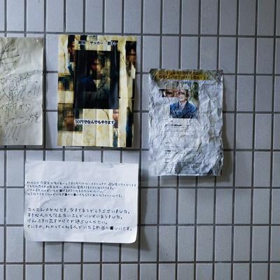 タイル壁に浮かぶ怪文書の掲示板の写真