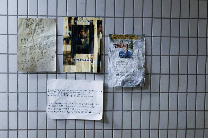 タイル壁に浮かぶ怪文書の掲示板の写真