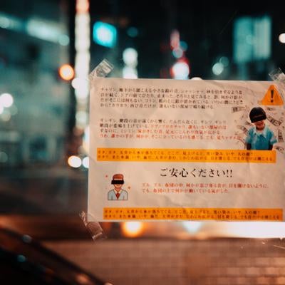 繁華街の夜に現れる疑念の貼り紙の写真