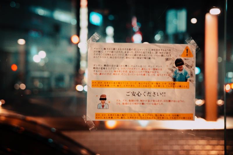 繁華街の夜に現れる疑念の貼り紙の写真