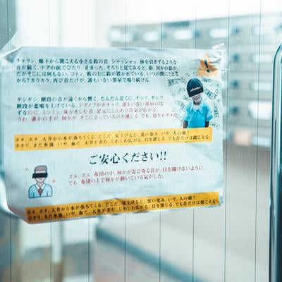 エントランス前に貼られた表向きは注意、裏側の真実の写真