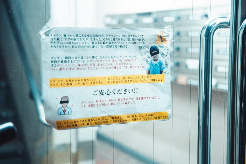 エントランス前に貼られた表向きは注意、裏側の真実の写真