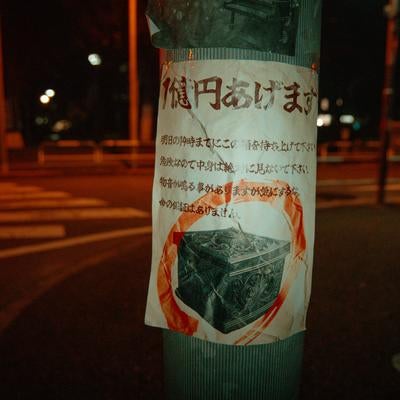 深夜の電柱に残る呪いの貼り紙の写真