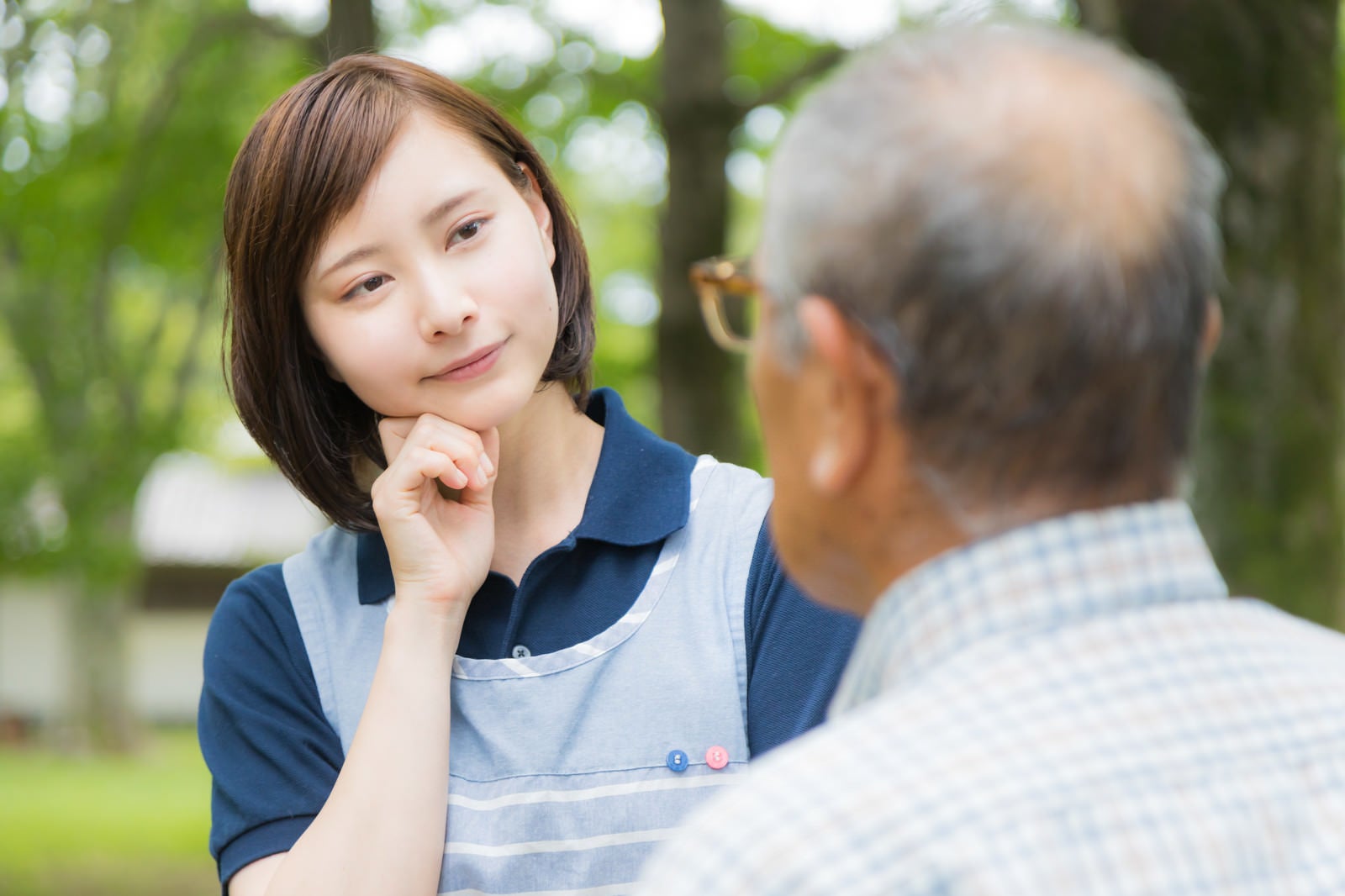 「頑固な老人と対話する介護士の女性」の写真［モデル：yumiko まーちゃん］