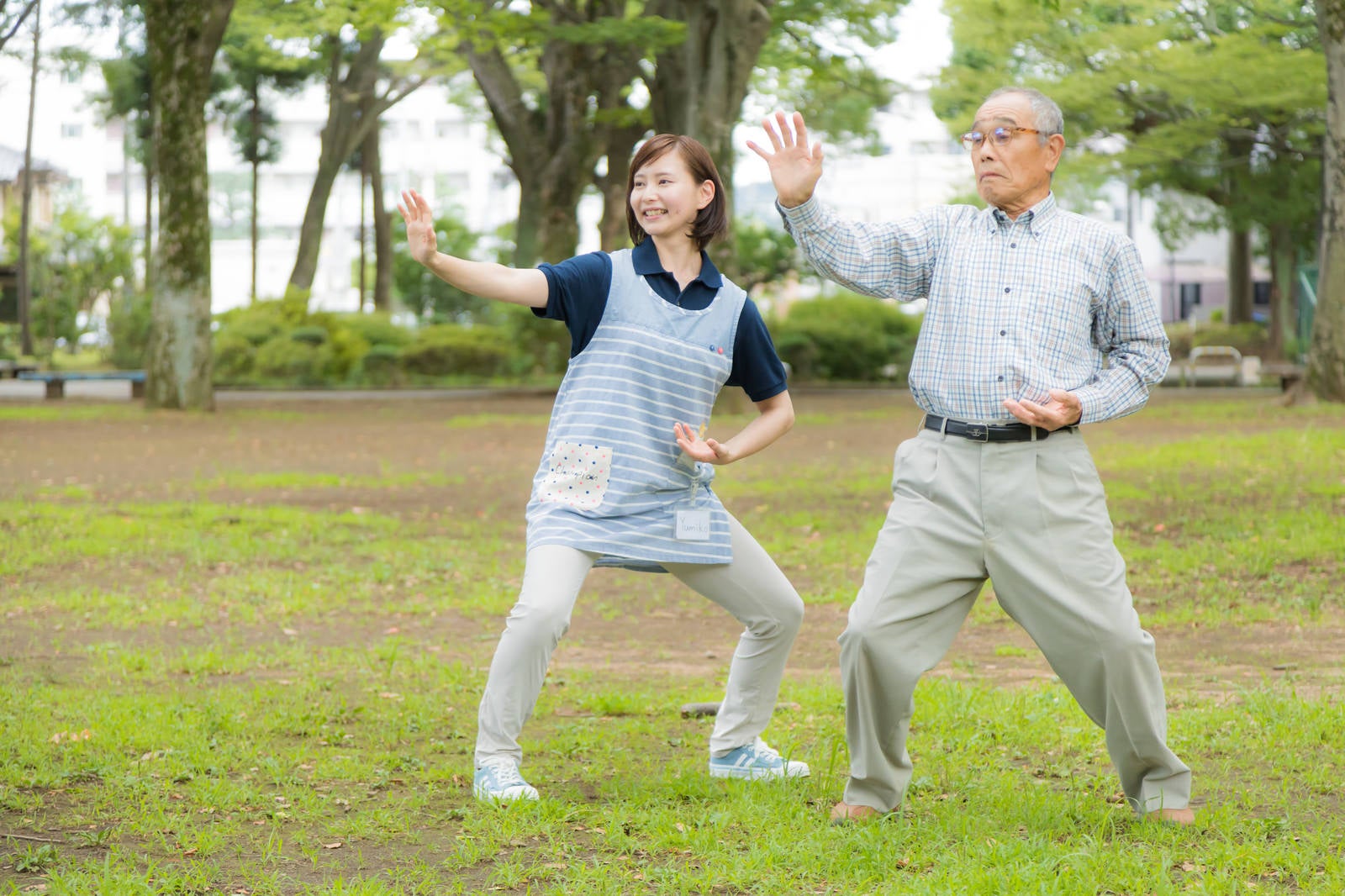 「お爺さんが毎朝日課にしている体操に付き合う介護士の女性」の写真［モデル：まーちゃん yumiko］