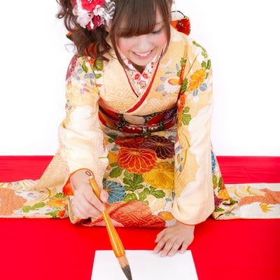 新年の書き初めをする着物の女性の写真