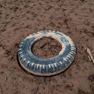 干上がった湖底に埋まる廃タイヤの写真