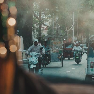 カンボジアの都市部でよく見られるトゥクトゥクが走るの写真