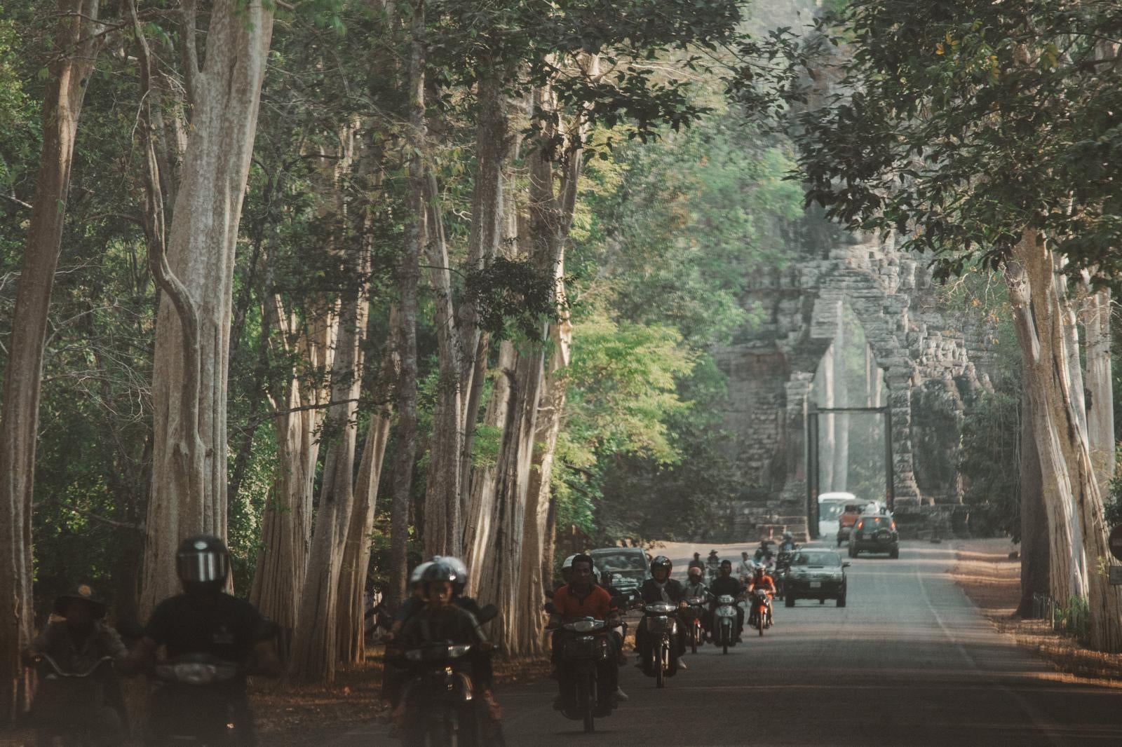 「シェムリアップ近郊にある「アンコール・トム（Angkor Thom）」の南大門を通過するバイクと車」の写真