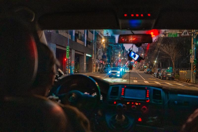 運転席越しに見た対向車のヘッドライトの写真