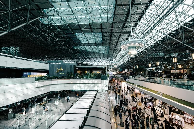 ガラス天井が印象的な国際空港の出発ロビーの写真