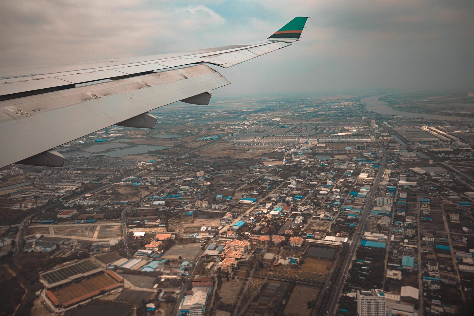 「飛行機の窓際席から撮影した都市上空の眺望」の写真