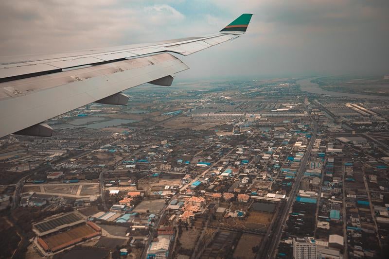 飛行機の窓際席から撮影した都市上空の眺望の写真