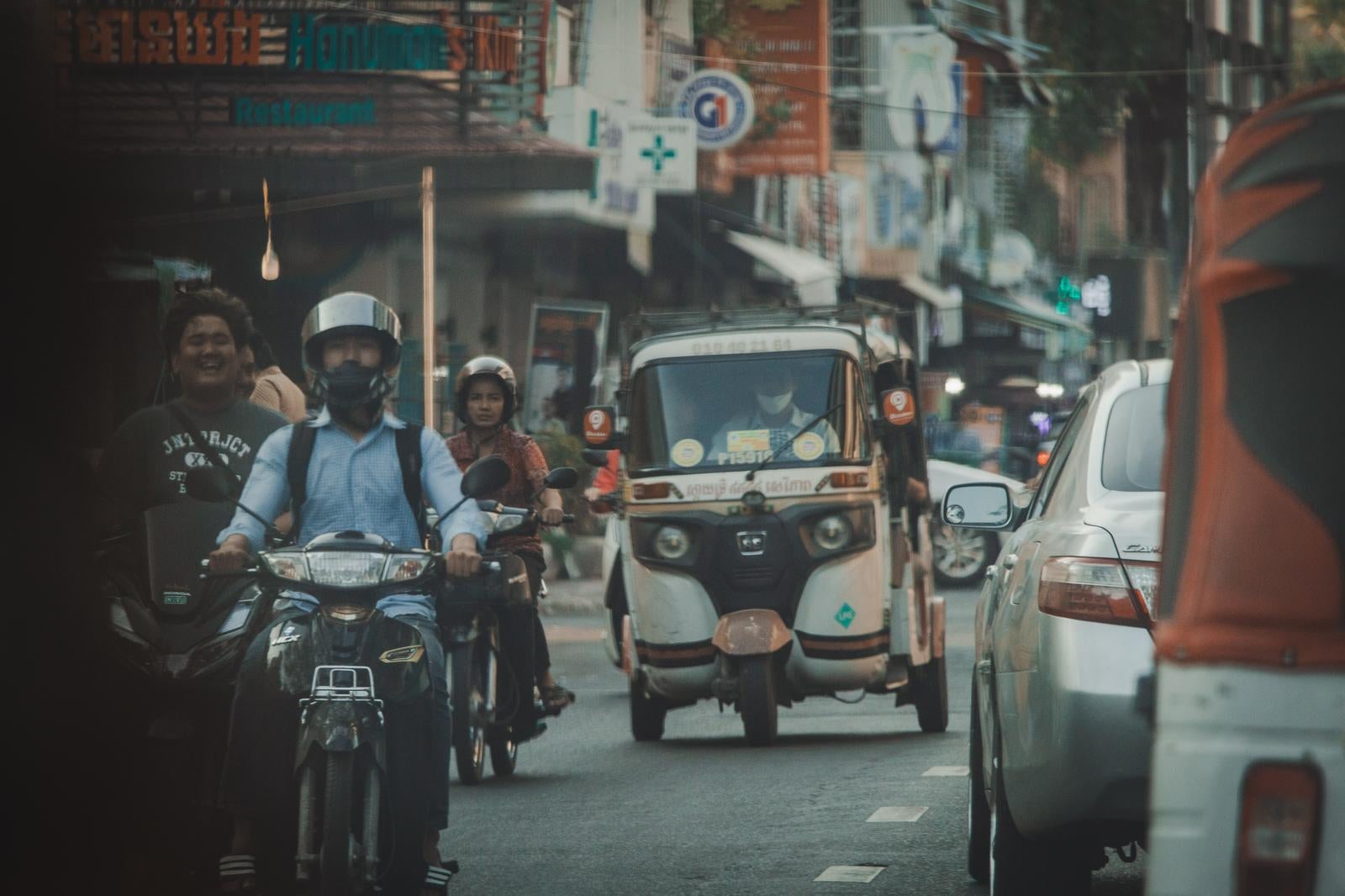 「活気あふれる市街地を行き交うバイクとトゥクトゥク」の写真