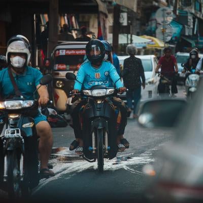 細い市街地の通りをバイクが走り抜ける様子の素材