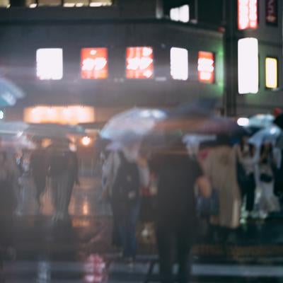 錦糸町駅前の横断歩道を渡る傘をさす通行人の写真