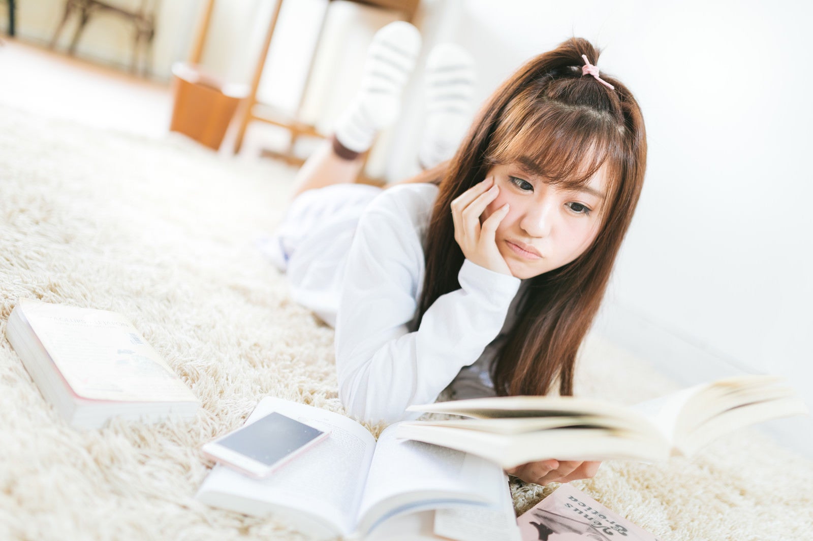 「部屋で課題の本を読む女子大生」の写真［モデル：河村友歌］