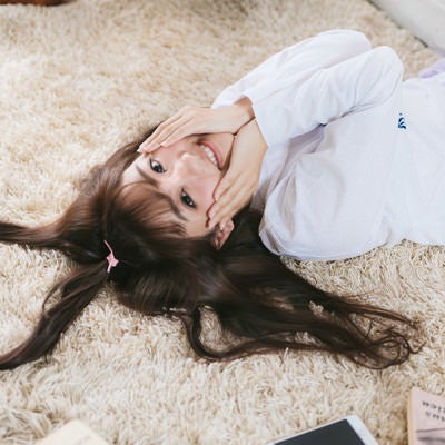 髪の毛でハートのかたちをつくる笑顔の女子の写真