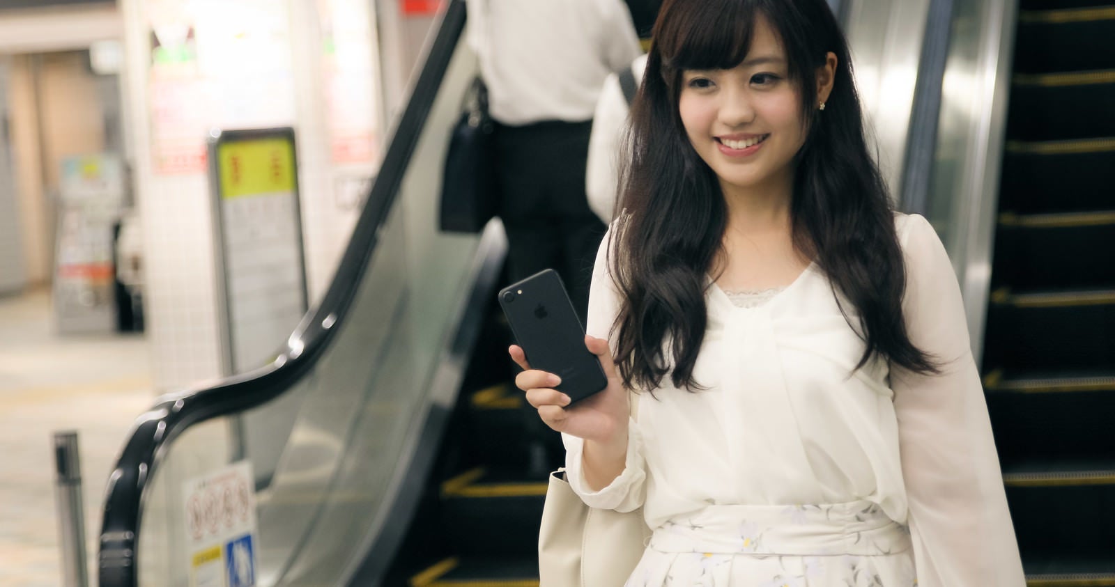 「財布や定期券を出さずにスマートフォンで駅の改札を出る女性」の写真［モデル：河村友歌］