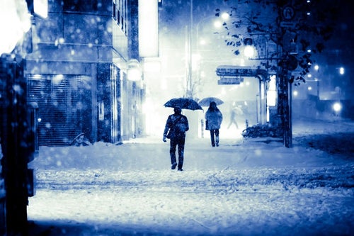 積雪で電車が止まり傘を差して家路に向かうの写真
