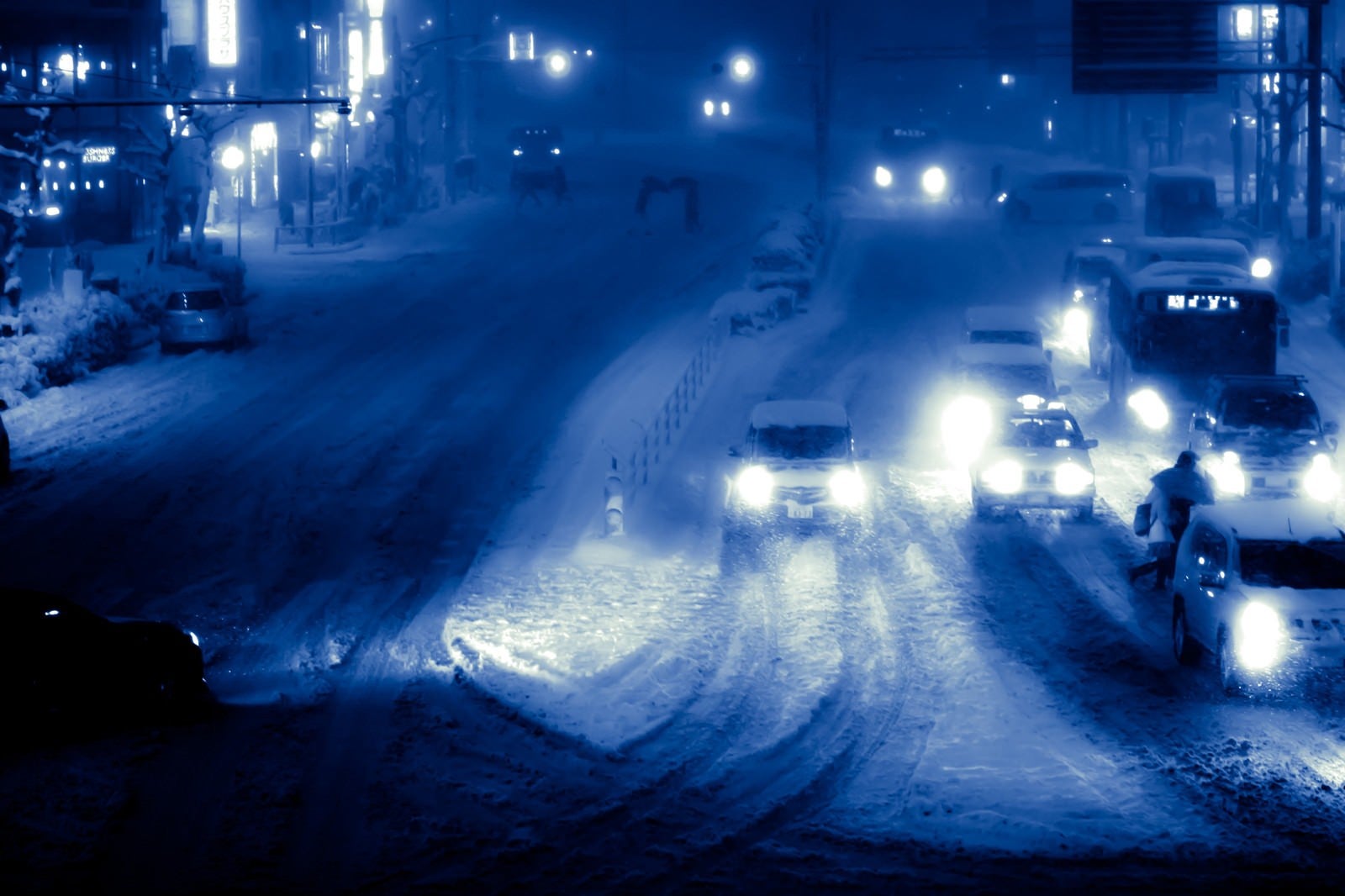 「雪が降り積もる夜の幹線道路」の写真