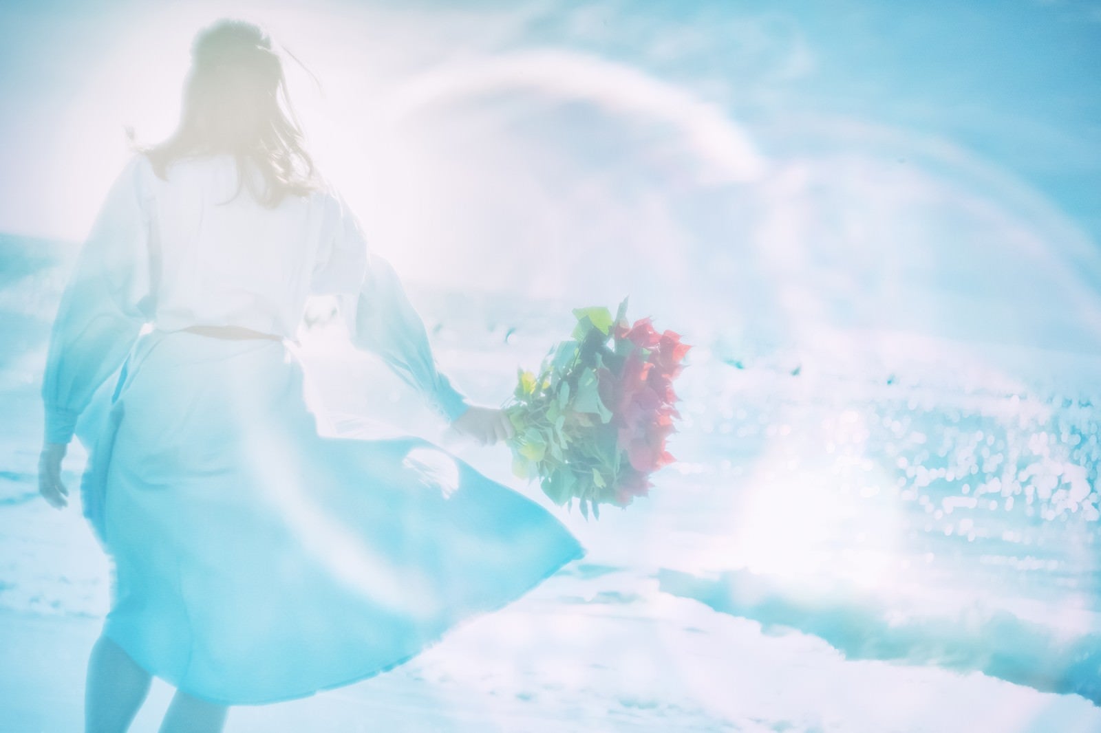 「海辺で花束を持つ女性（フォトモンタージュ）」の写真