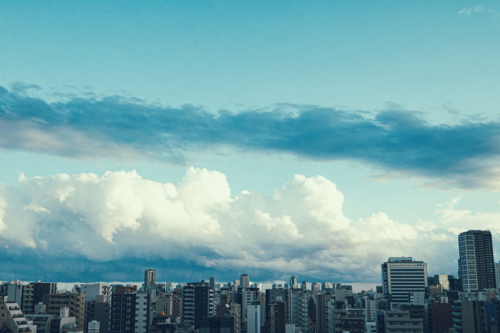 「都会のマンションと雲空」の写真