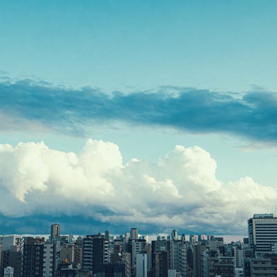 都会のマンションと雲空の写真