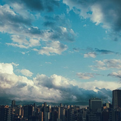 上空に晴れ間と雨雲の街並みの写真