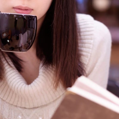 カフェでコーヒーを飲みながら読書女子の写真