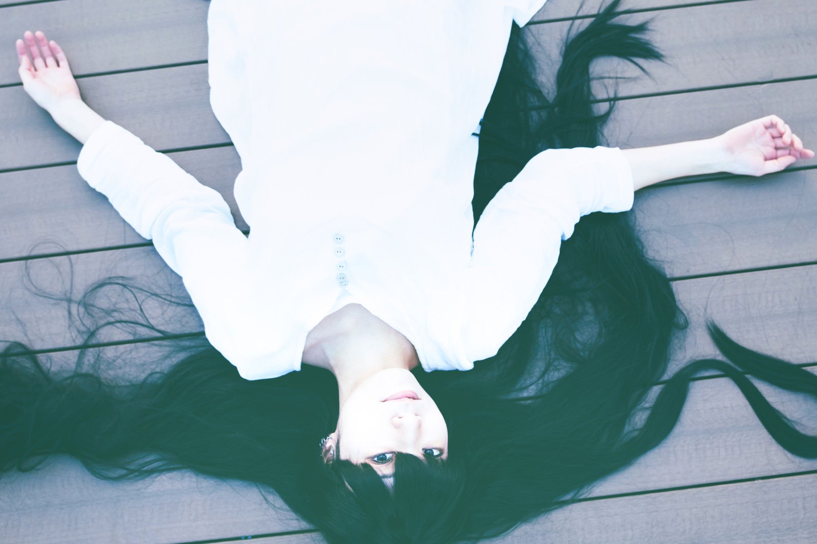 「床に倒れ込む髪の長い女性」の写真［モデル：緋真煉］