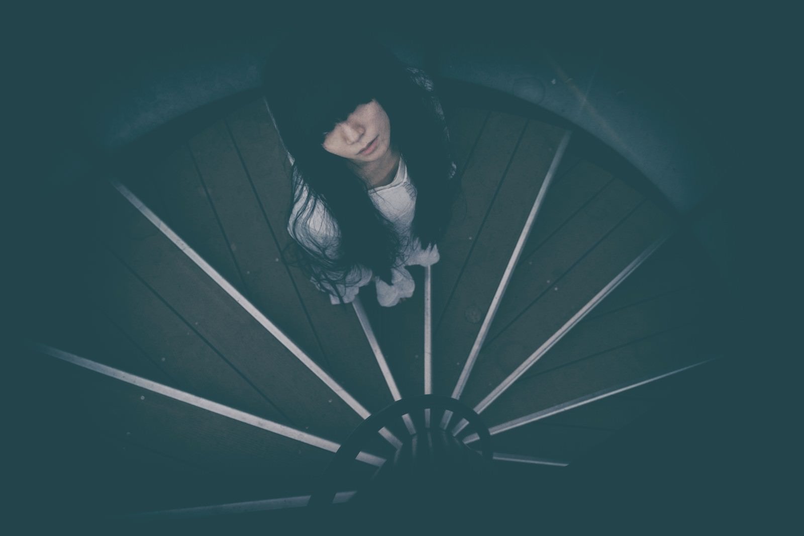 「どこまでも続く螺旋階段を見上げる女性」の写真［モデル：緋真煉］