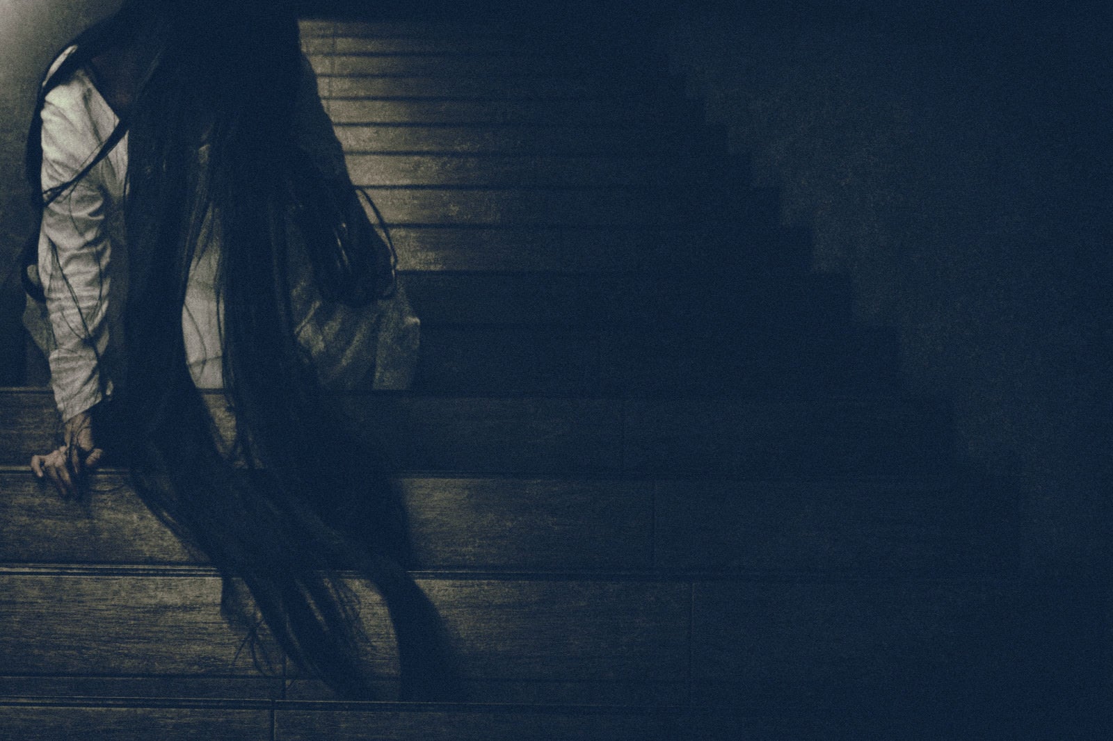 「髪の毛を垂れ下げ階段に居座る女性」の写真［モデル：緋真煉］