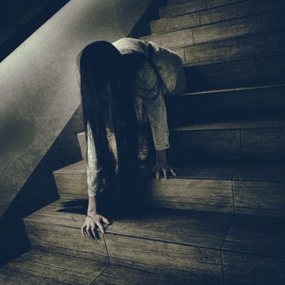 階段に座った状態からゆっくりと首を擡げようとする女性の写真