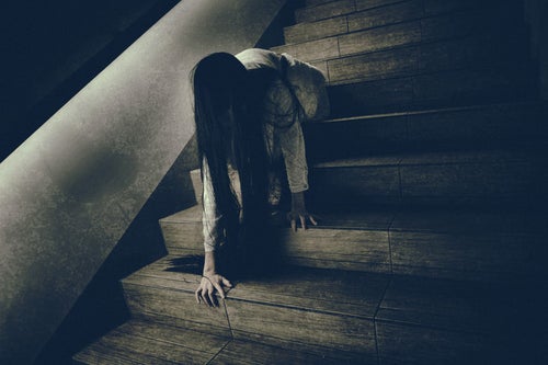 階段に座った状態からゆっくりと首を擡げようとする女性の写真
