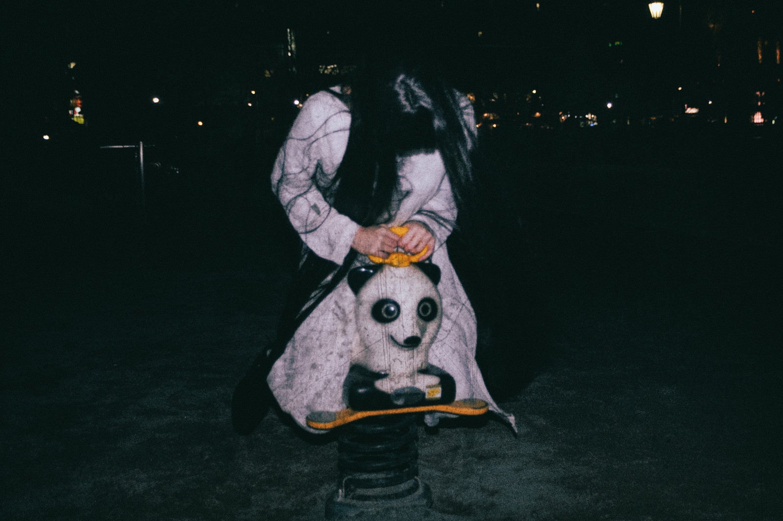 「深夜の公園でパンダのスプリング遊具に乗った気味の悪い女性」の写真［モデル：緋真煉］