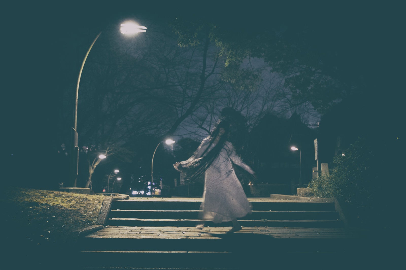 「深夜の公園で不気味な動きをする女性」の写真［モデル：緋真煉］