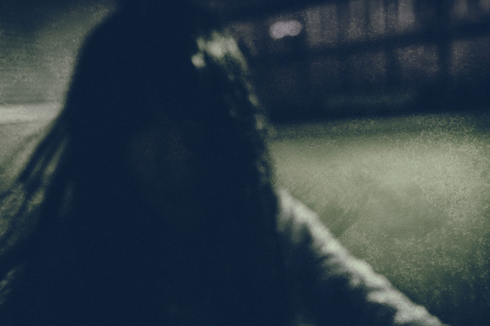 「暗がりの中で髪を振り乱す女性」の写真［モデル：緋真煉］