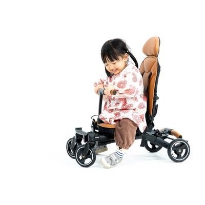 足で蹴って進む！ベビーカーのライドモードで自由に遊ぶ女の子の写真