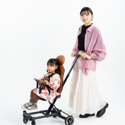 B型ベビーカーに座る女の子と女性の写真