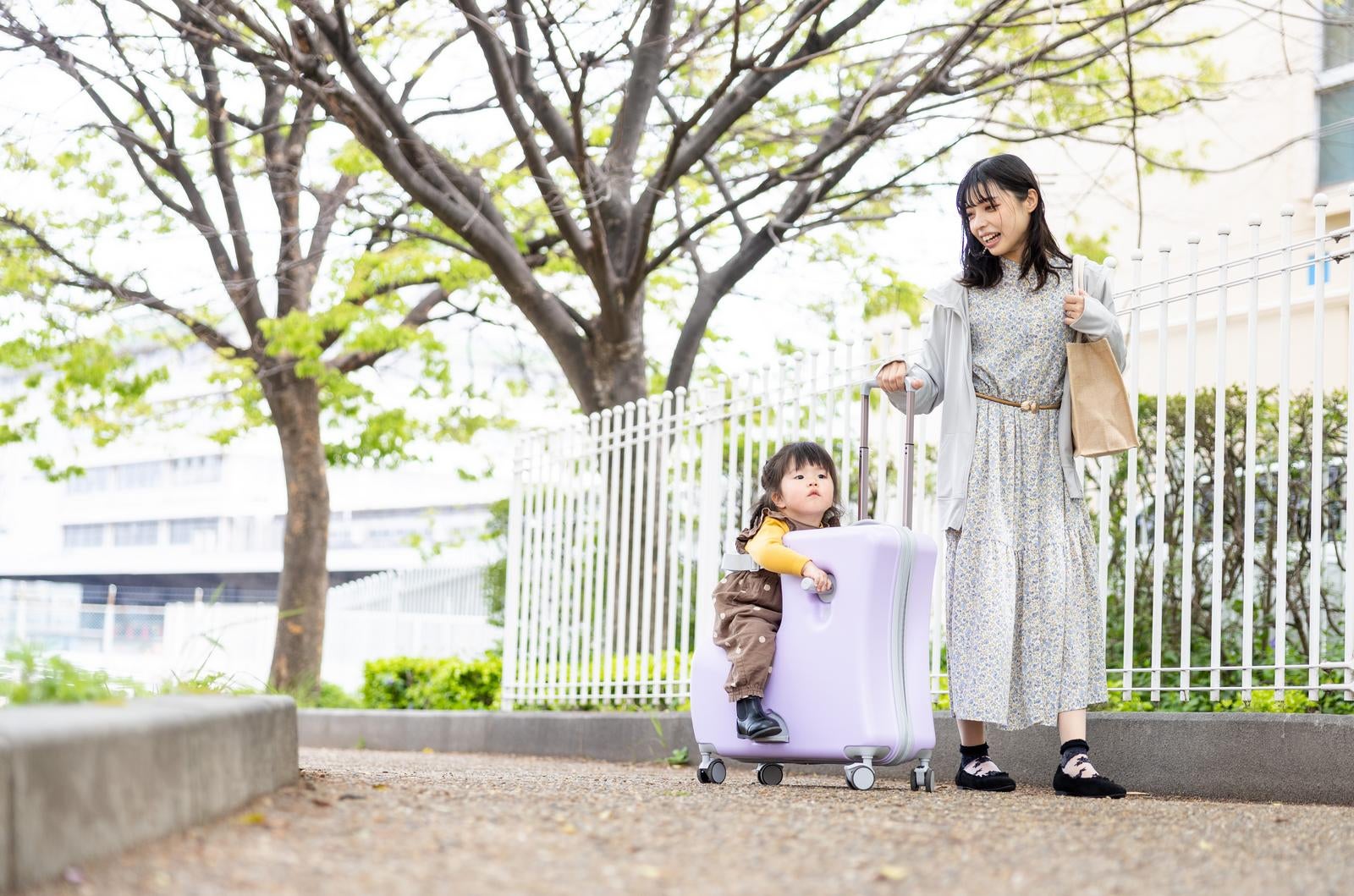 「キャリーケースに乗って親子でおでかけ」の写真