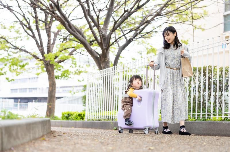 キャリーケースに乗って親子でおでかけの写真