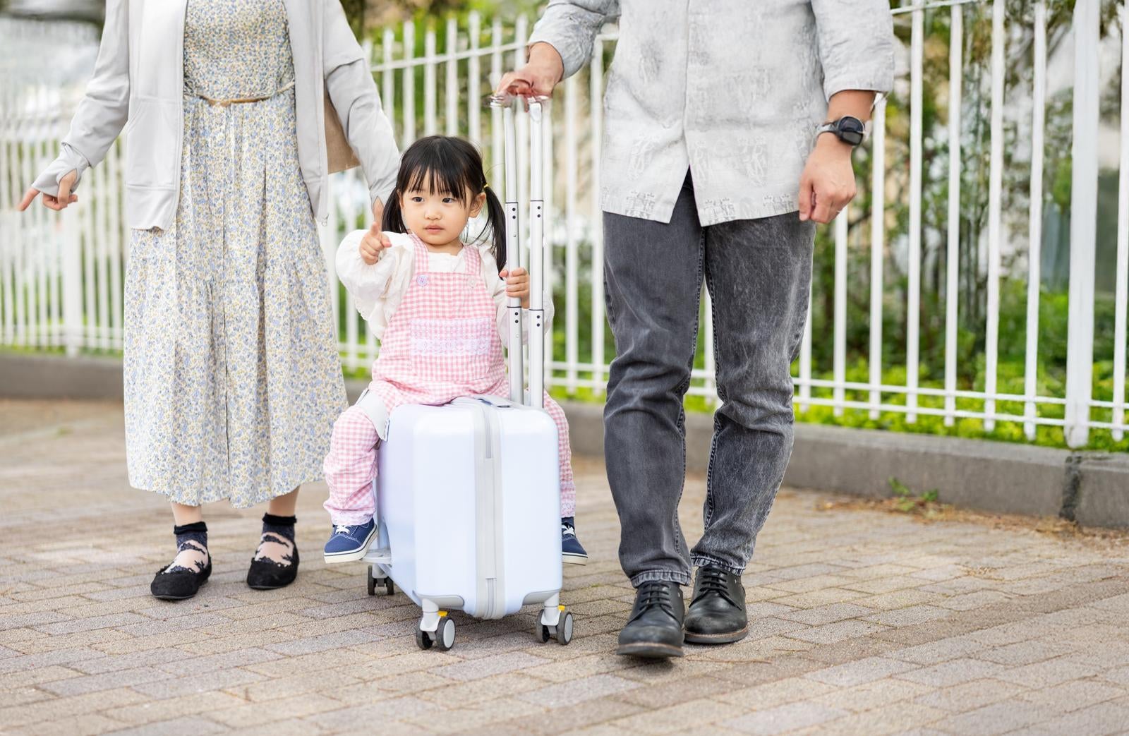 「パパとママに囲まれて、キャリーケースで楽々移動」の写真