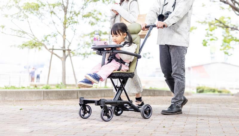 ベビーカーに乗りながらスマホを見る女の子の写真