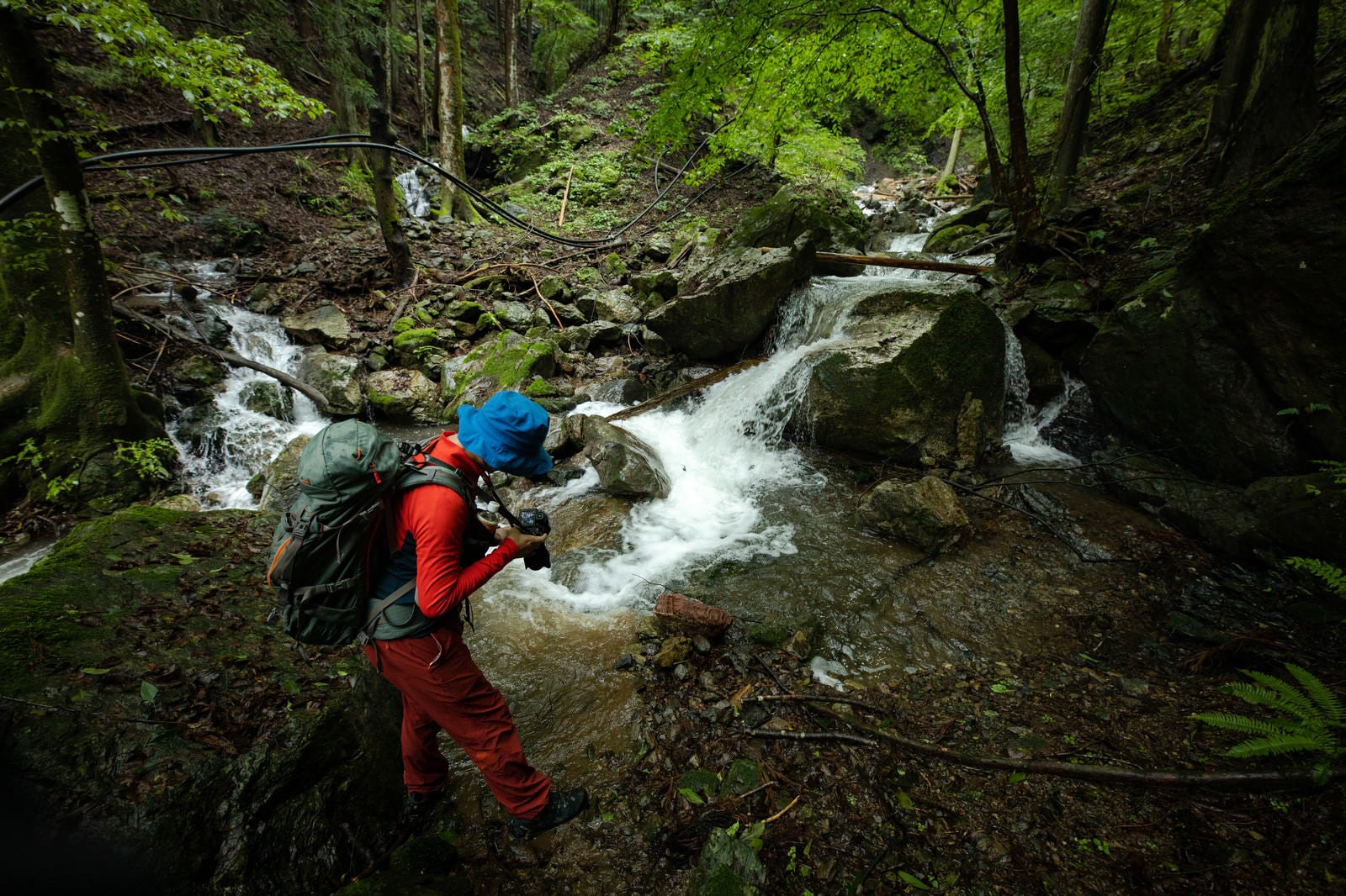 「渓流の様子を撮って出しする登山家カメラマン」の写真