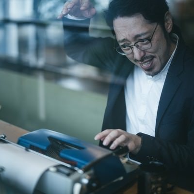 一心不乱にタイプライターをたたく男性の写真