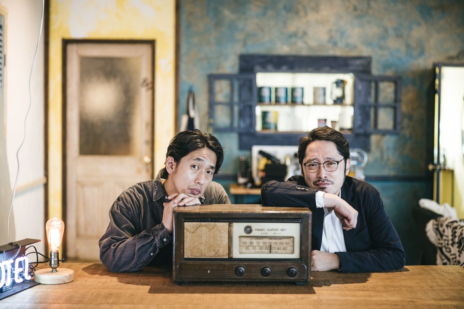 「ラジオと一緒に記念写真を撮る二人組の男性」の写真［モデル：大川竜弥 ゆうせい］