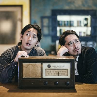 周囲を威嚇する男性と考え込む男性の写真