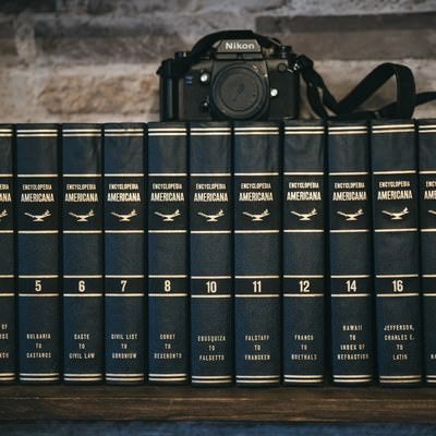 本棚に並んだ百科事典とカメラの写真