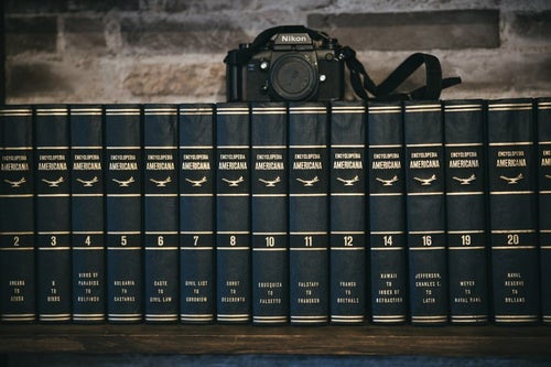 本棚に並んだ百科事典とカメラの写真